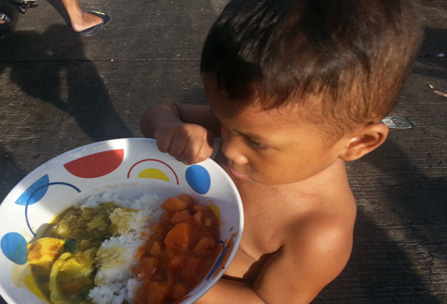 A Young Boy Accepts A Nourishing Meal in the Philippines