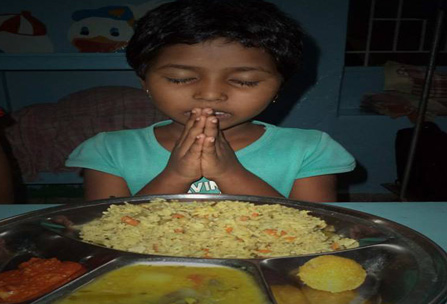 A Hungry Girl Prays In Gratitude for A Hot Meal at Neura HoPE Learning Center in Goa, India